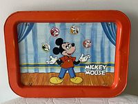 Front of tray showing Mickey Mouse juggling design and red rim
