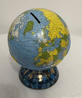 Front view of tin globe bank on zodiac pedestal