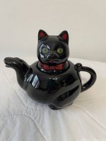 Front view of black cat teapot with lid in place