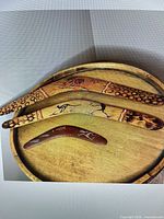 Front view of three boomerangs showing painted decoration and sizes