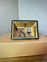 Front view of signed carved wood diorama showing interior scene