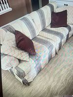 Top view of sofa showing patterned upholstery and two burgundy pillows