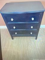 front view showing three drawers and metal knobs