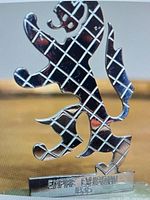 Front view showing metal lion outline, inscription, and jade base