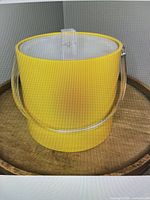 Front view of yellow lucite ice bucket with clear lid and handle