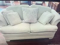 Front view of loveseat with cushions and pillows