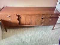 Front view of credenza showing drawers, sliding doors, overall finish