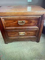 Front view of one nightstand showing two drawers with brass pulls