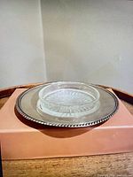 Glass insert nested on silverplate base viewed side angle