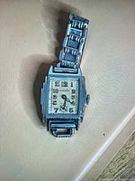 Front view of Ronson wristwatch showing dial, case shape and bracelet attachment