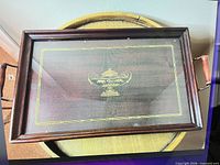 Top view of rectangular wooden tray with glass top and gold urn design