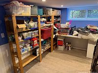 Three shelving units filled with various totes, boxes and items