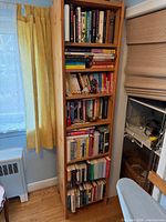 Full view of tall five-shelf unit filled with books
