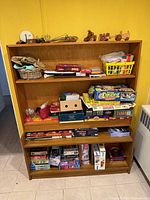 Full bookcase with board games, puzzles and decor visible