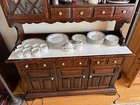 Cabinet top showing entire dish set including plates, cups, serving pieces