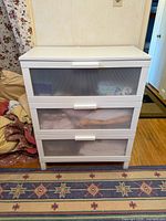 Front view of the chest showing all three translucent drawers and white frame