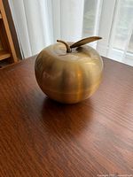 Oblique view of gold apple box showing overall shape and finish