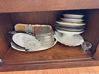 Overall lot inside cabinet showing variety of glass and ceramic pieces