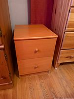 Front and side view of one nightstand showing drawers and finish