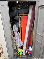 Full shed view showing cushions, rolled rug, fabric panels and other supplies