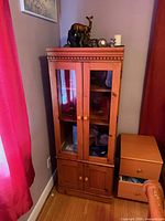 Front view of full cabinet showing glass doors and lower storage