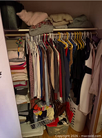 Closet with hanging garments, folded items, baskets; overall view