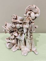 Front view of Benedini ceramic musicians figurine showing three players and antique white/brown finish