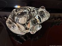 Left side view of clear glass frog candle holder with votive recess visible