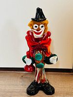 Front view of multicolor glass clown figurine, shows overall shape and colors