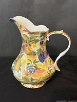 Side view of Royal Danube pitcher showing fruit motif and form