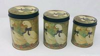 Front view of three graduated duck-themed metal canisters