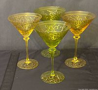Four martini glasses in two colours with gold scroll decoration
