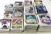 Eight stacks of baseball cards displaying various front cards and thickness of lot