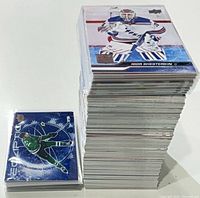 Tall stack of standard Upper Deck hockey cards next to smaller stack of sleeved insert cards