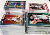 Two tall stacks and two shorter stacks of sleeved basketball cards on table