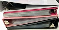 Stacked binders showing ring hardware and inserted pages