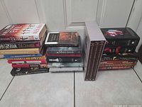 Two stacks of assorted hardcover books on floor
