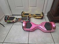 Three hoverboards arranged on floor showing top surfaces