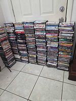 Stacks of roughly 400 DVD movies in cases against a door