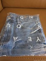 Jeans folded inside original AYR-branded plastic bag