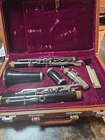 Clarinet body sections, mouthpiece and accessories in open burgundy velvet-lined case