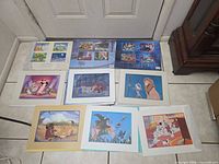 Nine lithograph pieces on floor showing sealed portfolios and loose matted prints