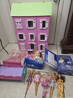 Overall lot showing dollhouse, cradle, boxed dolls and loose dolls