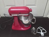 Full view of red KitchenAid mixer with stainless bowl and power cord