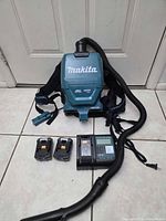 Full view of backpack vacuum with hose, batteries, charger