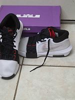 Shoes on floor with box lid showing LeBron logo
