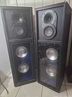 Front view of both Welton PS413Y speakers showing drivers and plexiglass panels