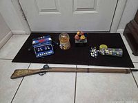 Lot overview showing accordion, globe, music box, marbles jar, and wooden rifle