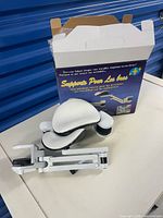 Both arm supports resting beside open retail box