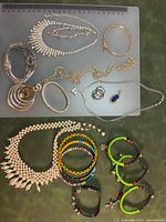 All items on cutting mat including bracelets, necklaces, pendants, two rings visible